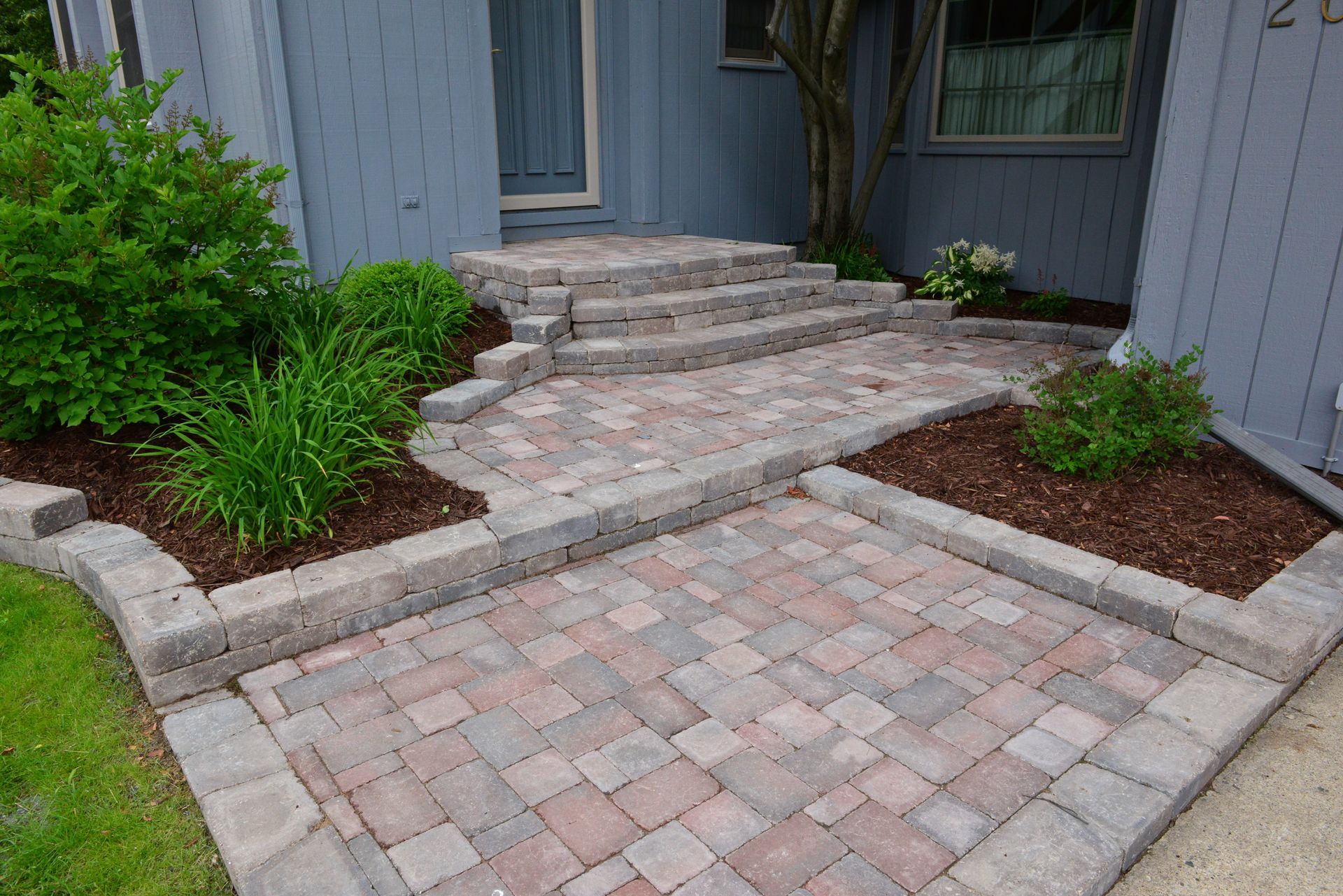A brick walkway leading to the front door of a house.