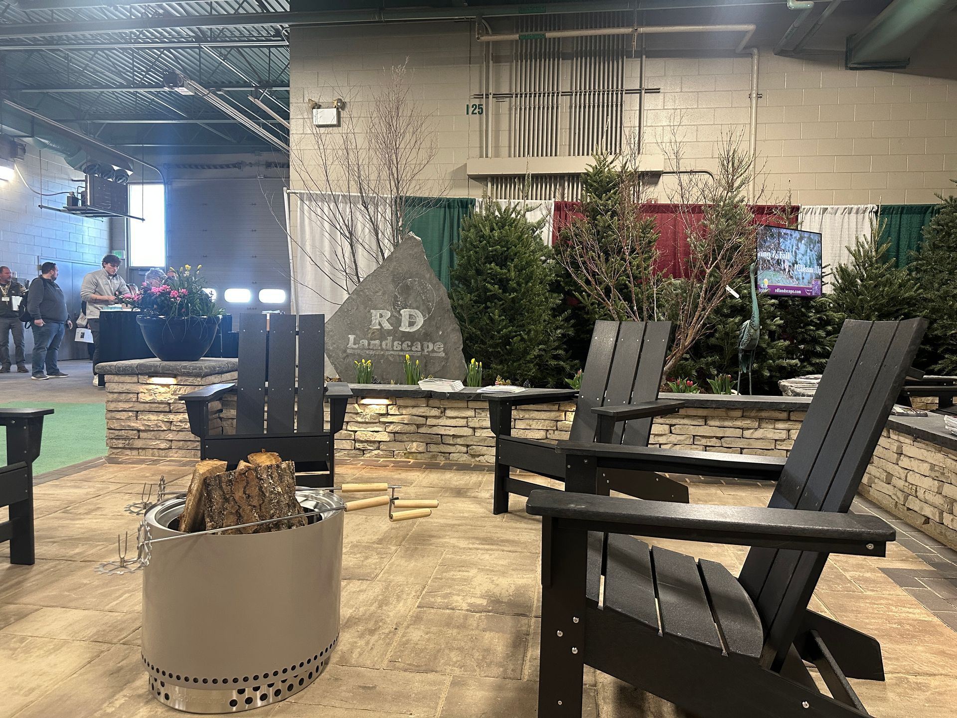 A group of chairs are sitting next to a fire pit in a room.