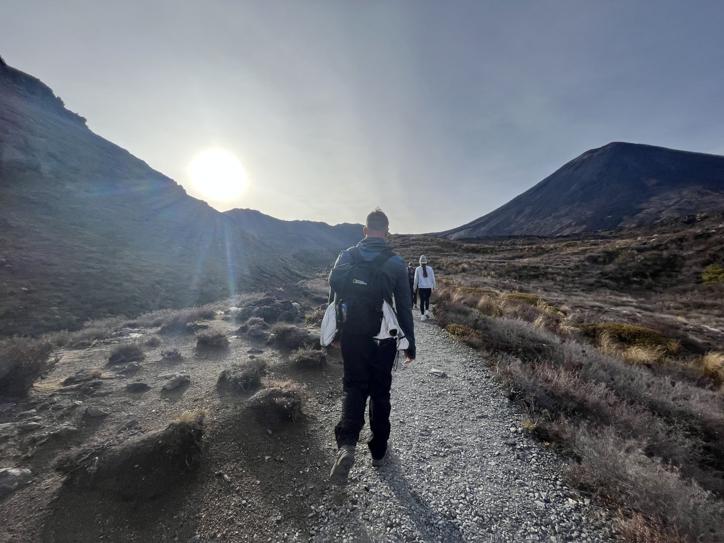 A hiker walking the Tongariro Alpine Crossing with Mount Ngauruhoe in the background