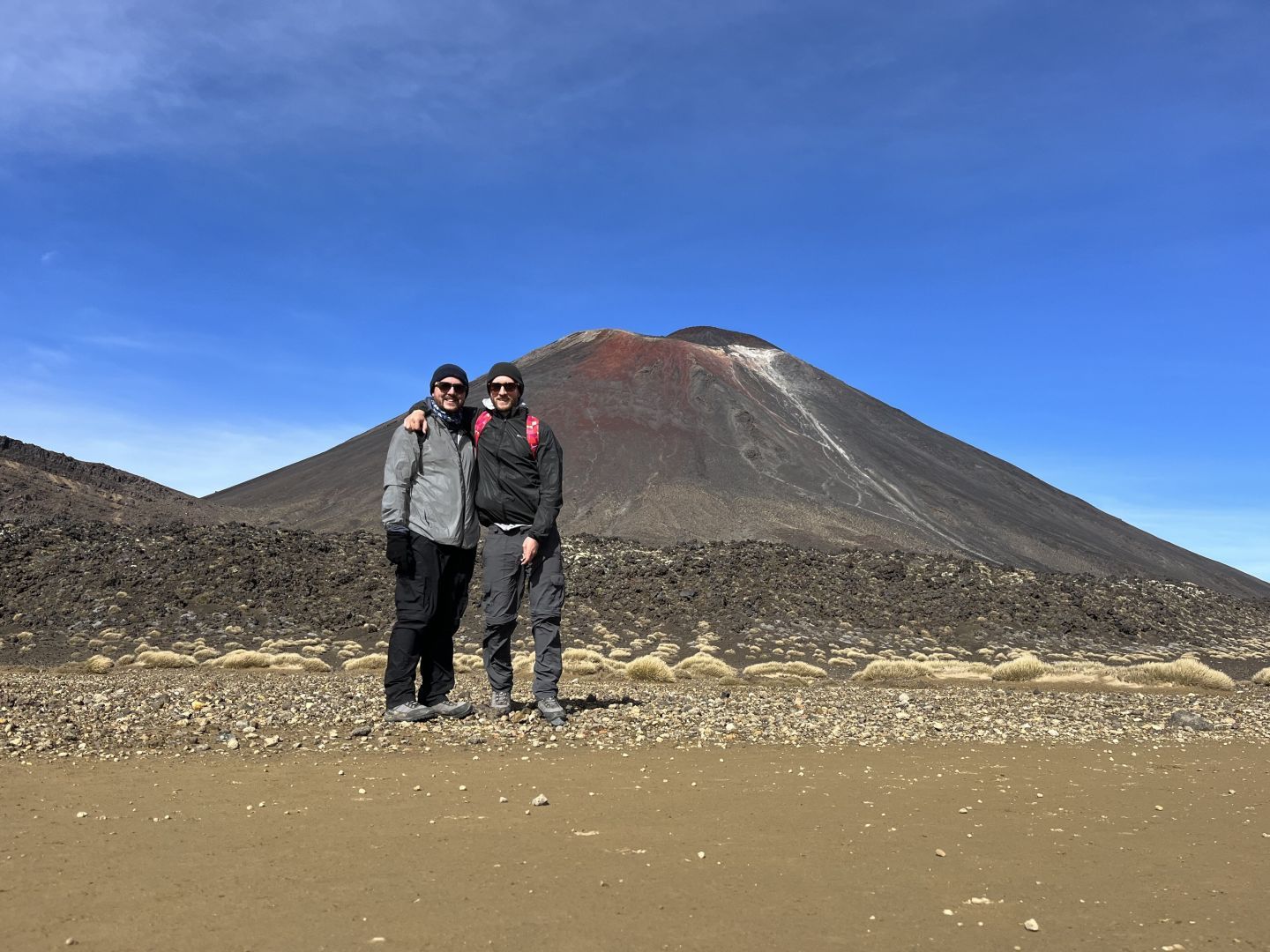 Two hikers posing for a photo in front on Mount Ngauruhoe