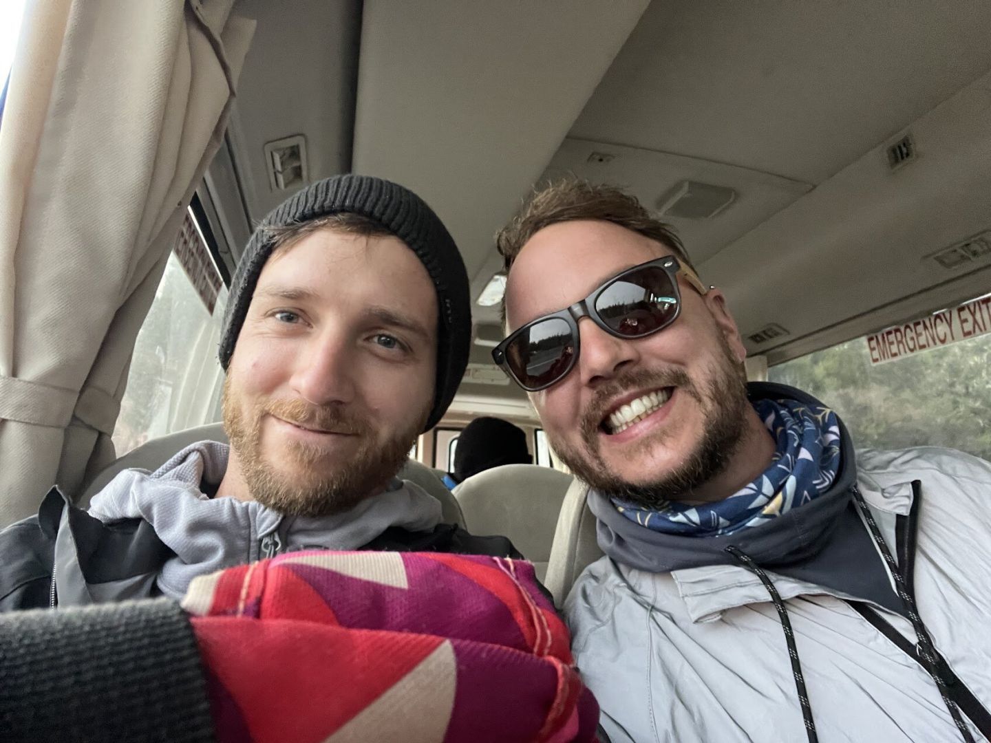 Two hikers in the Tongariro Expeditions shuttle bus on their way to the start of the Tongariro Alpine Crossing track
