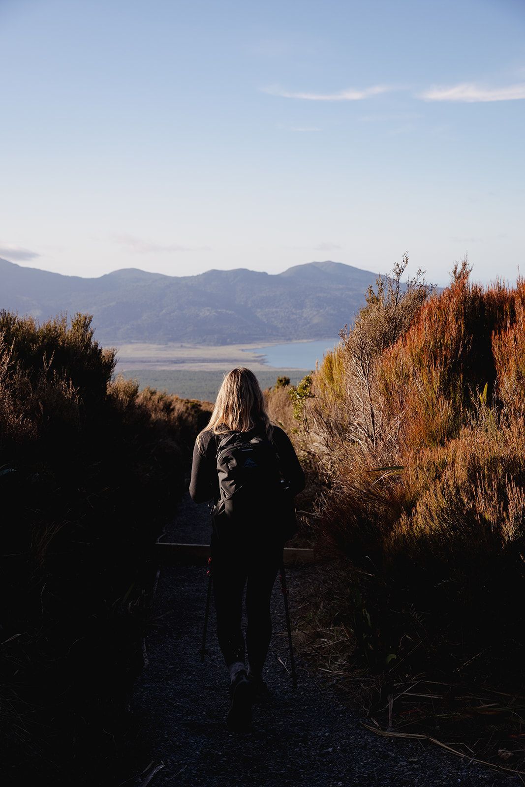 A person posing for a photo on a rock with Tongariro in the background