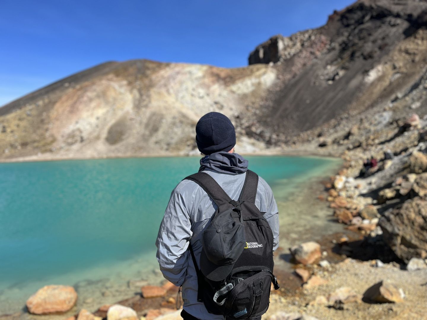 A hiker looking out over the Blue Lake on the Tongariro Alpine Crossing