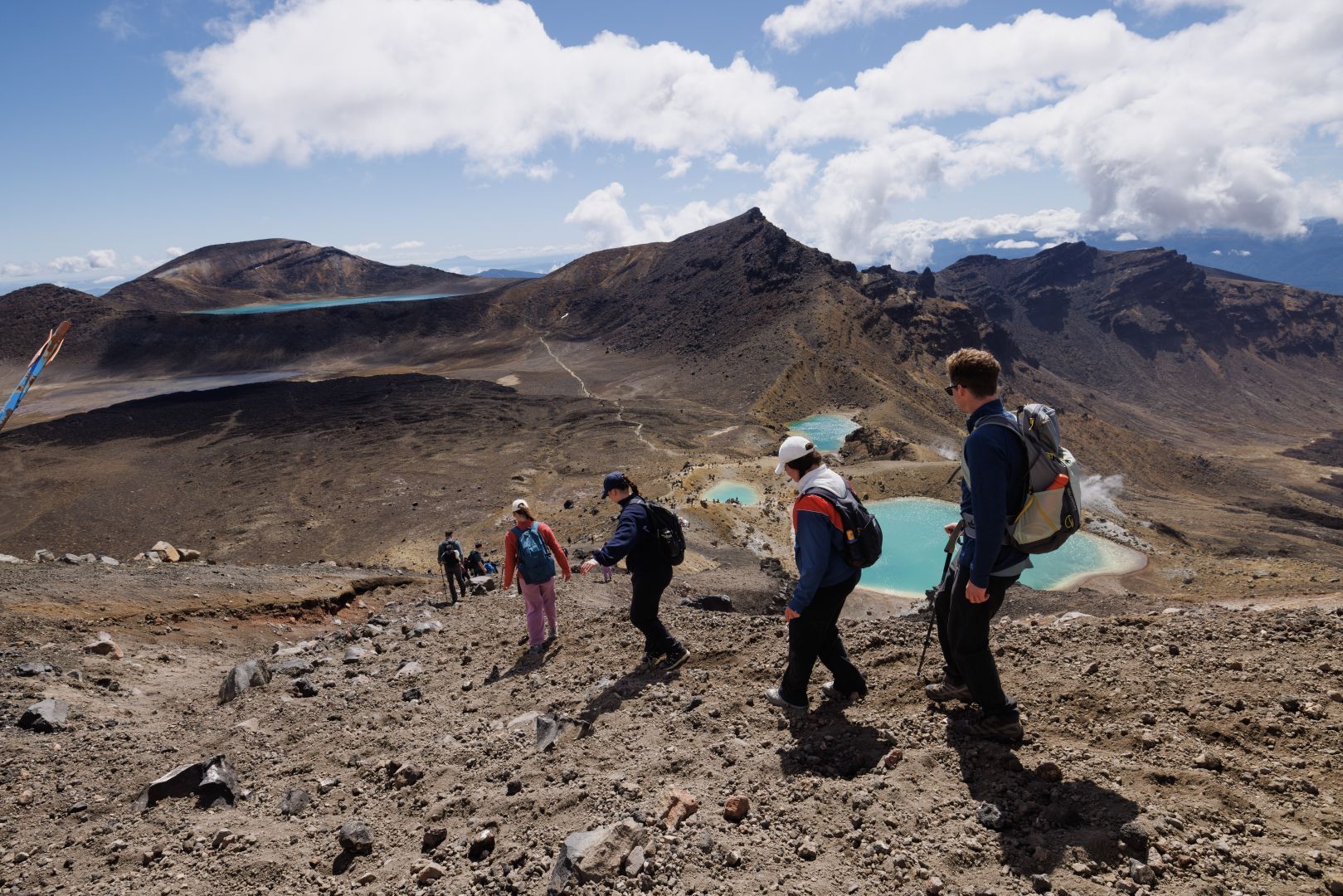 A group of people making their descent from the Emerald Lakes to the Blue Lake on the the Tongariro Alpine Crossing