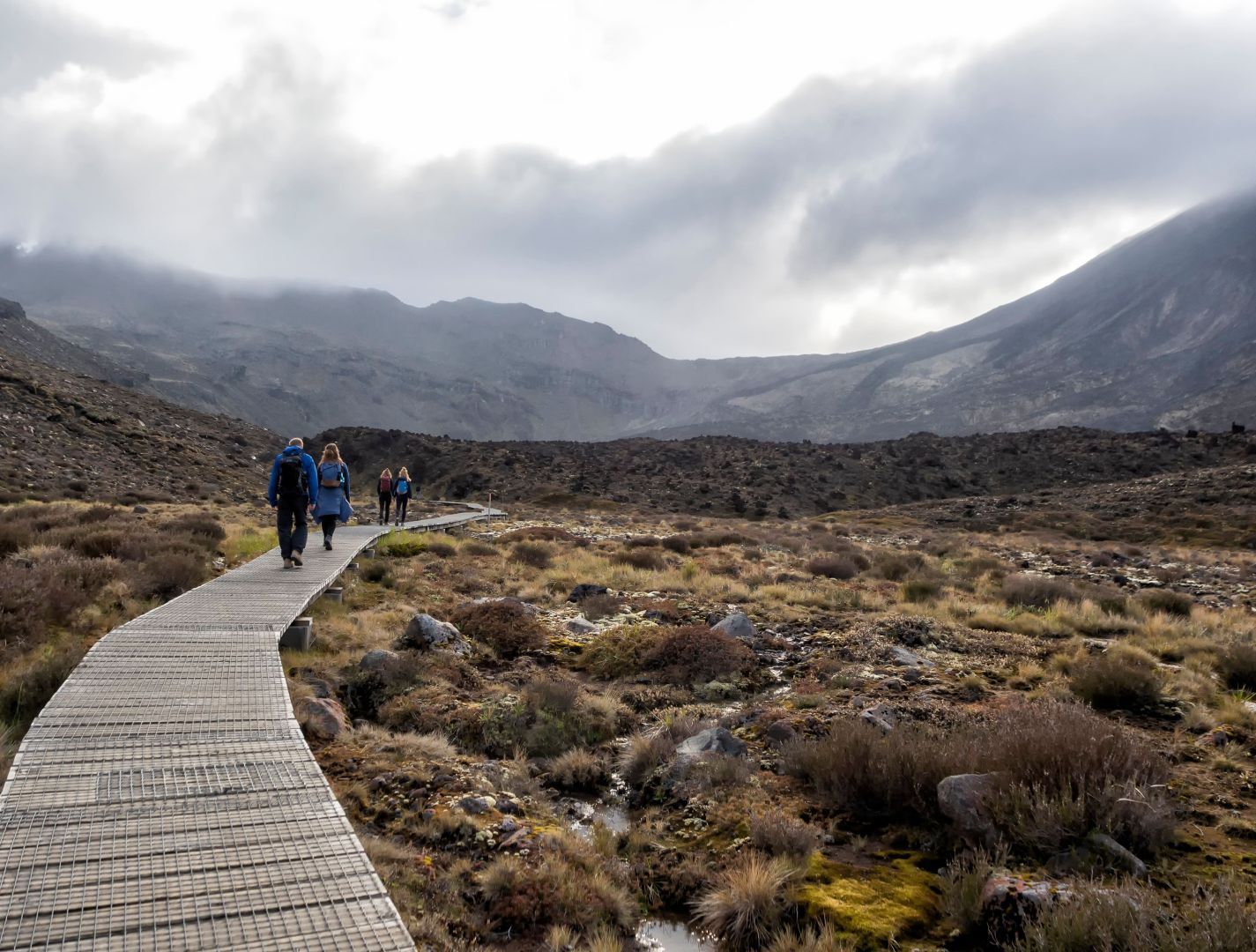 A group of hikers on a boardwalk section of the trail on the Tongariro Alpine Crossing