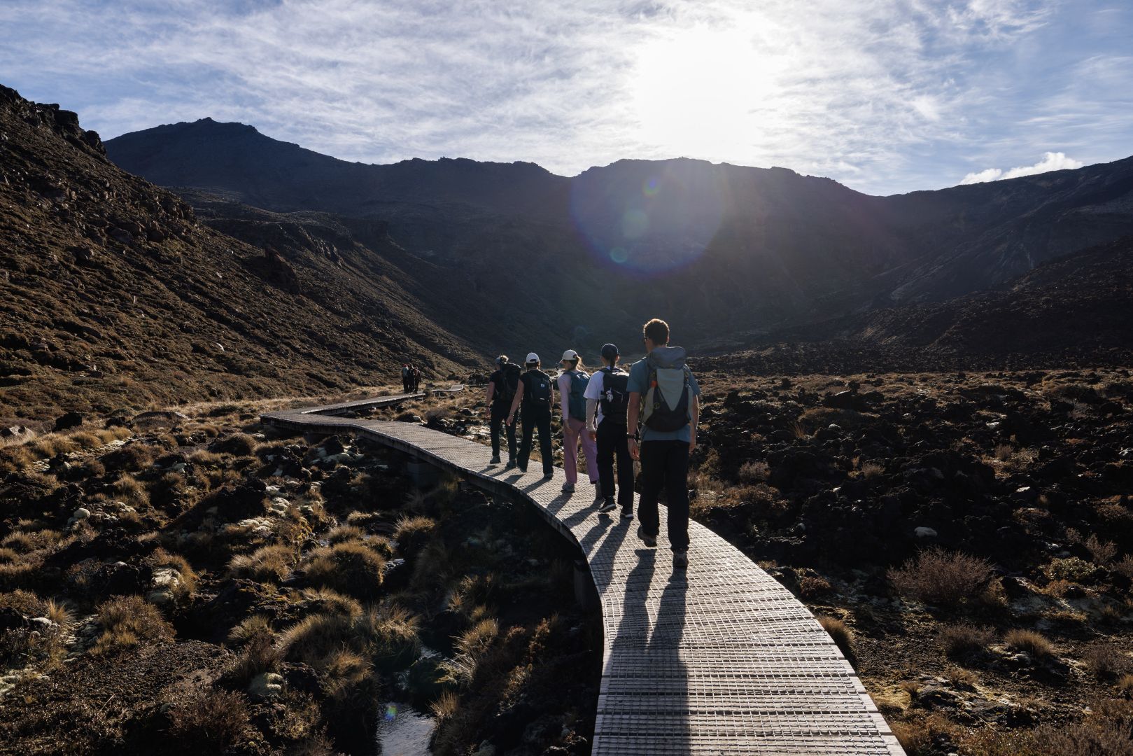 A group of people walking over a footbridge on the Tongariro Alpine Crossing