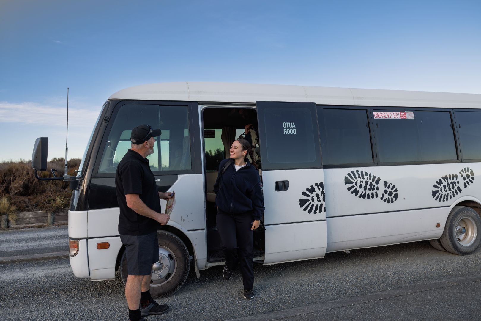 Guests departing the Tongariro Expeditions shuttle bus after being picked up from the Ketetahi car park