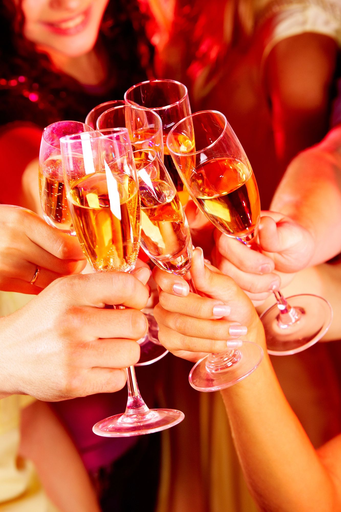 Le mani brindano con calici di champagne in un caloroso e festoso brindisi accompagnato da bevande frizzanti dorate.
