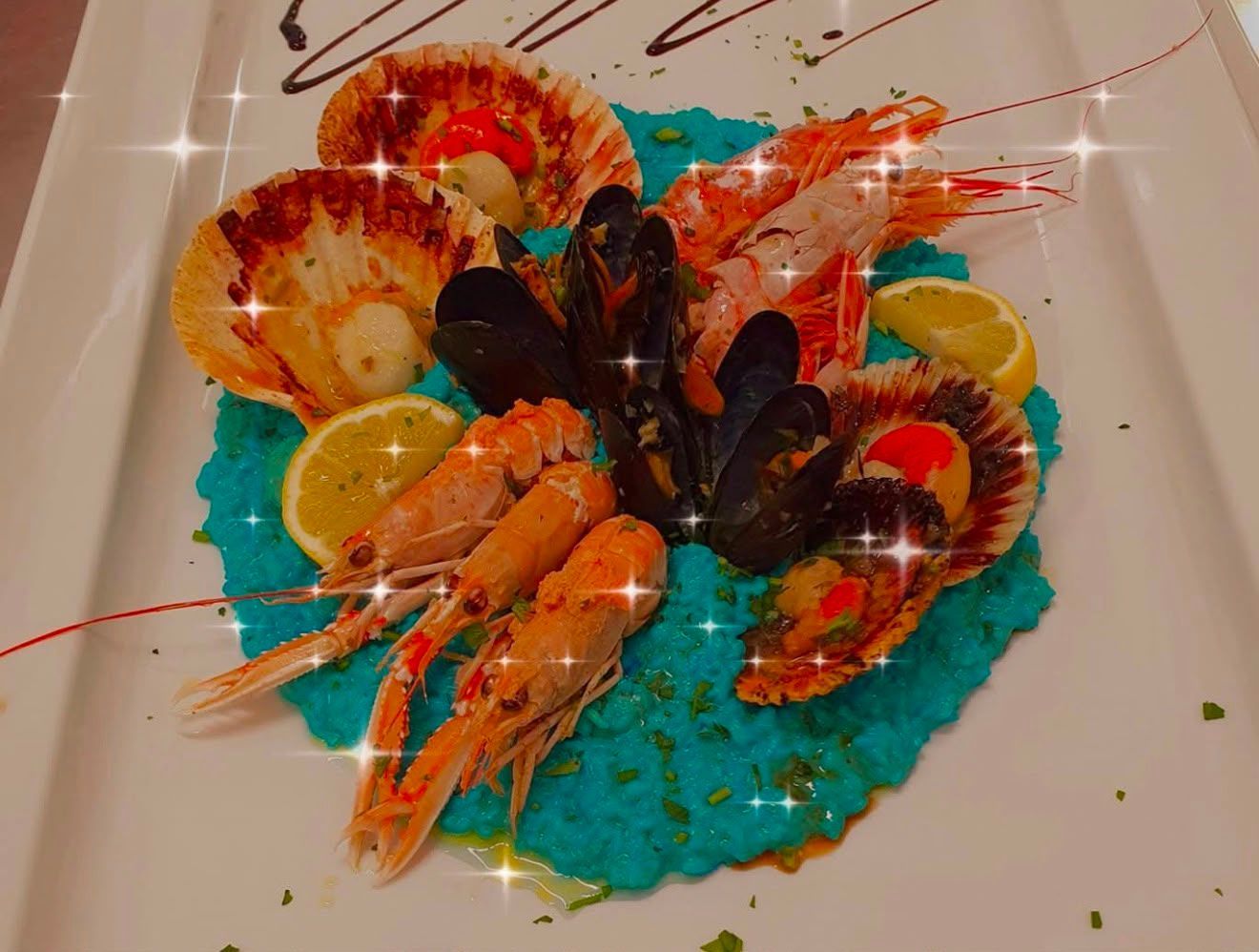 Piatto di frutti di mare con aragosta, gamberi, cozze e limone su riso blu.