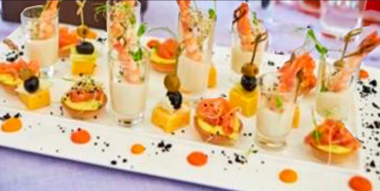 Elegante tavolo da dessert con mini pasticcini colorati e dettagli arancioni su un vassoio bianco.