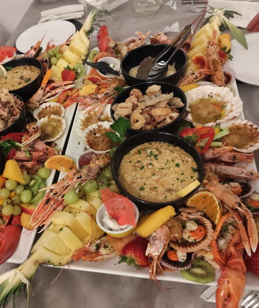 Piatto di frutti di mare con granchio, gamberi, ostriche e salse per intingere, disposto su un tavolo.