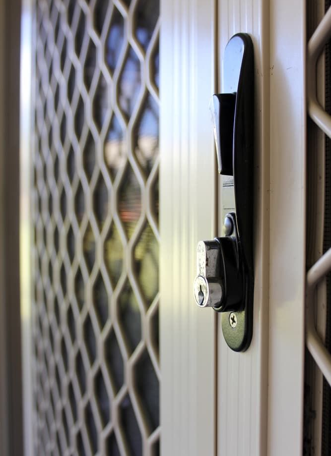 Black handle and lock on a white security screen door — Everything Screendoors & More In Wollongong, NSW