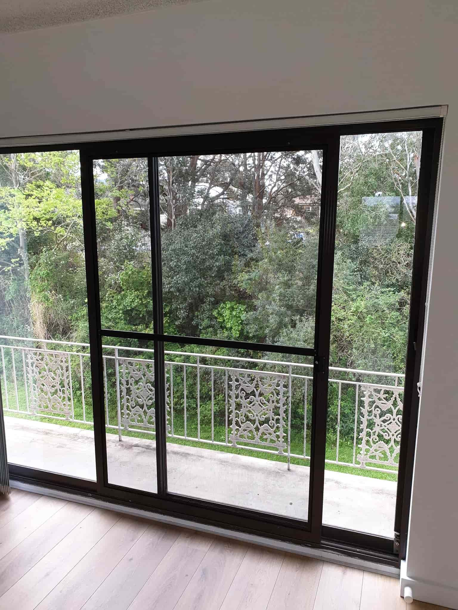 An Empty Room With a Balcony and Sliding Glass Doors — Everything Screendoors & More In Wollongong, NSW
