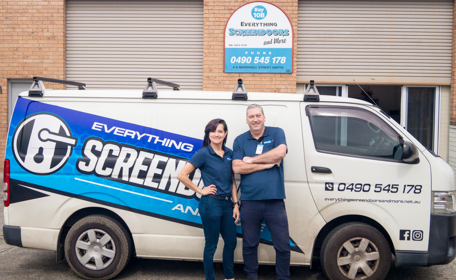 Two people stand by a van with
