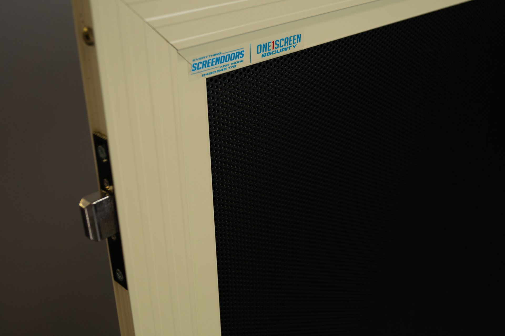 Close-up of a beige screen door, showing a black mesh screen and lock — Everything Screendoors & More In Wollongong, NSW
