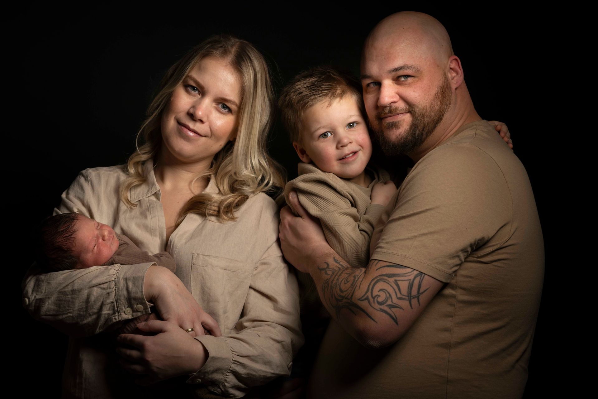 Een gezin poseert voor een foto met een pasgeboren baby.