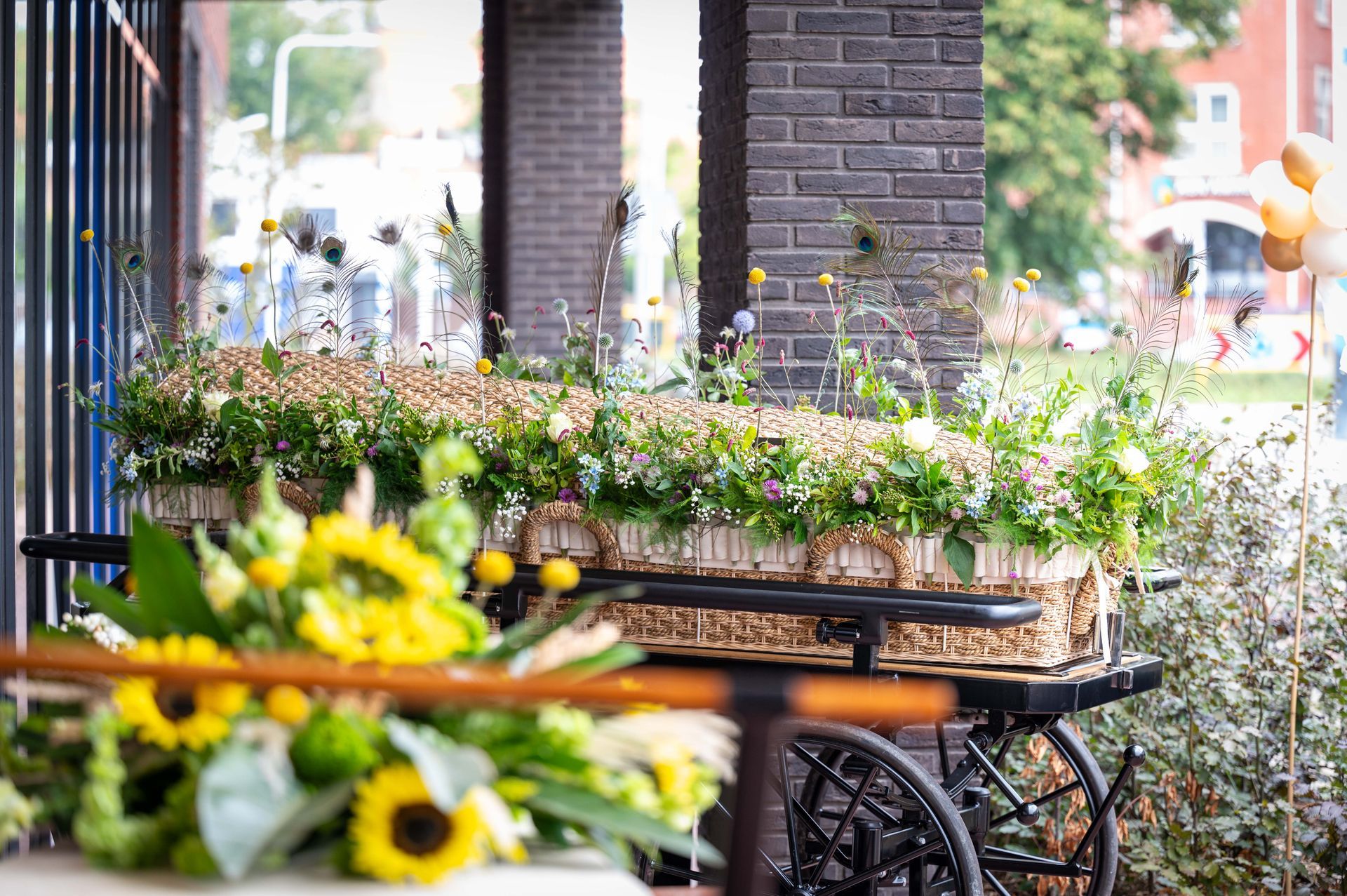 Foto bij de opendag van UitvaartinZeeland van een mandkist en bloemband 