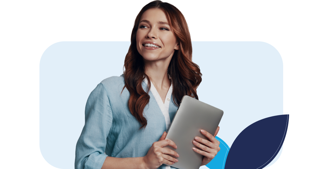 Uma mulher está segurando um laptop nas mãos e sorrindo.