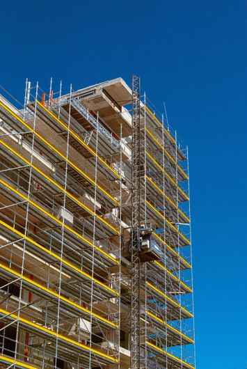 Stanza parzialmente ristrutturata con scatole a muro a vista, attrezzi e materiali sparsi sul pavimento.