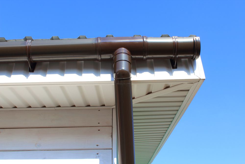 A Brown Gutter Is Attached To The Roof Of A House — Fullerton's Plumbing Manufacture In Woree, QLD