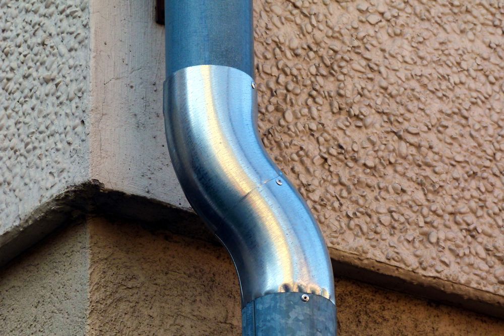 A Close Up Of A Metal Pipe On The Side Of A Building — Fullerton's Plumbing Manufacture In Woree, QLD