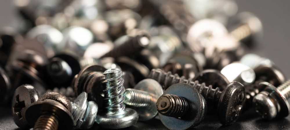 A Pile Of Screws And Nuts On A Table — Fullerton's Plumbing Manufacture In Woree, QLD
