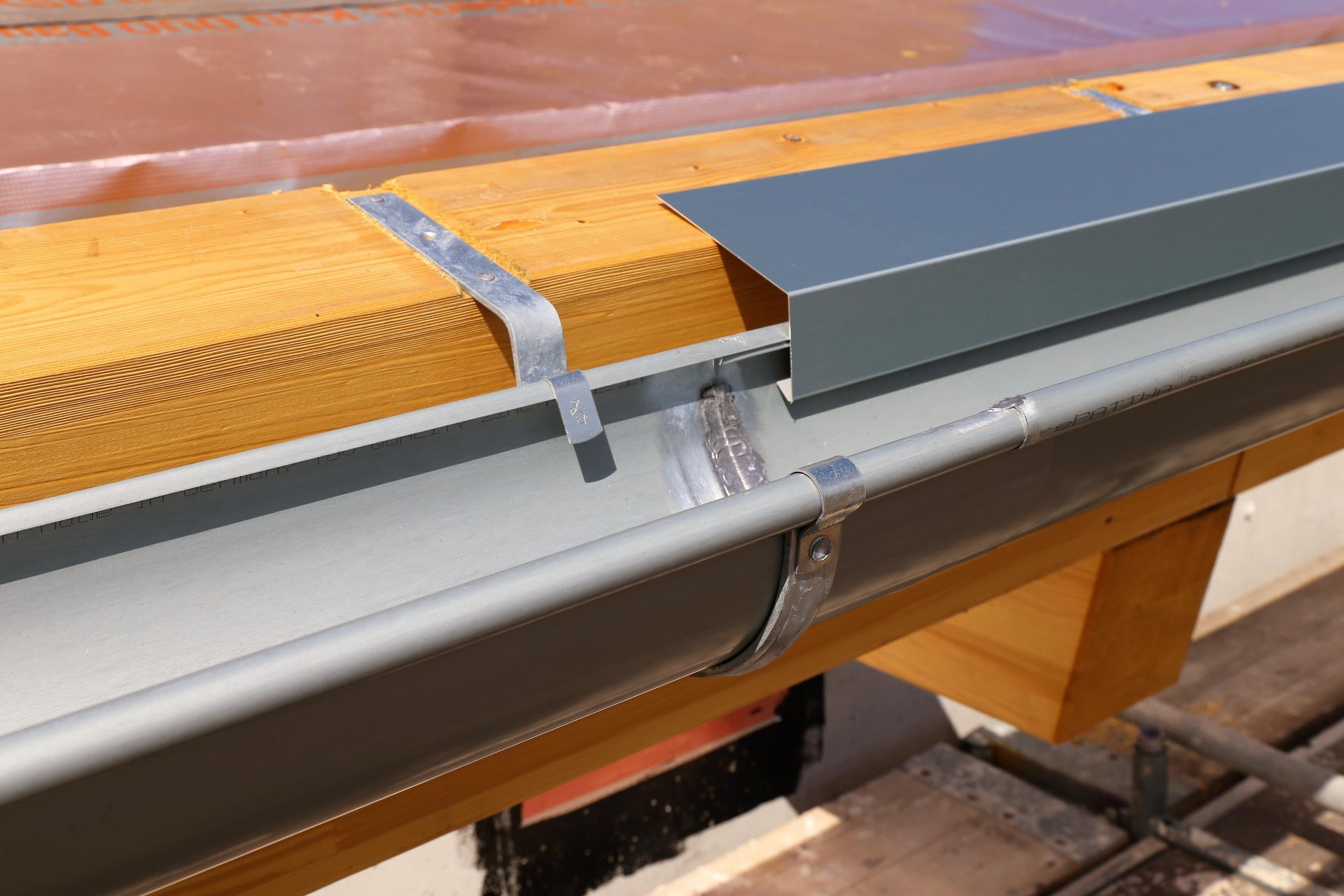 A Gutter Is Being Installed On A Wooden Roof — Fullerton's Plumbing Manufacture In Woree, QLD