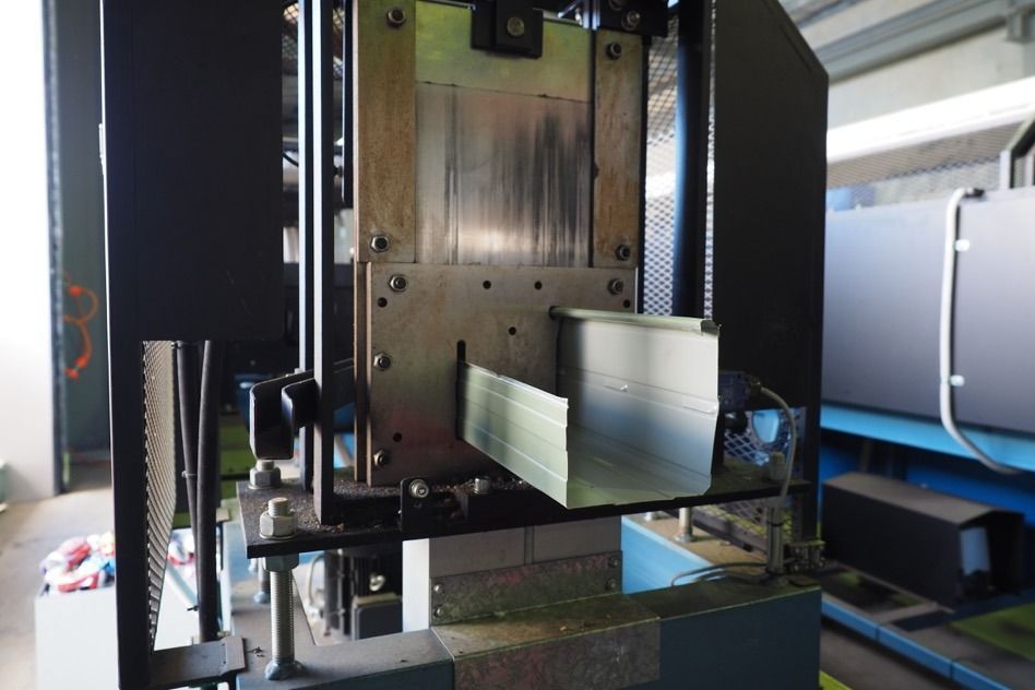A Machine Is Cutting A Piece Of Metal In A Factory — Fullerton's Plumbing Manufacture In Woree, QLD
