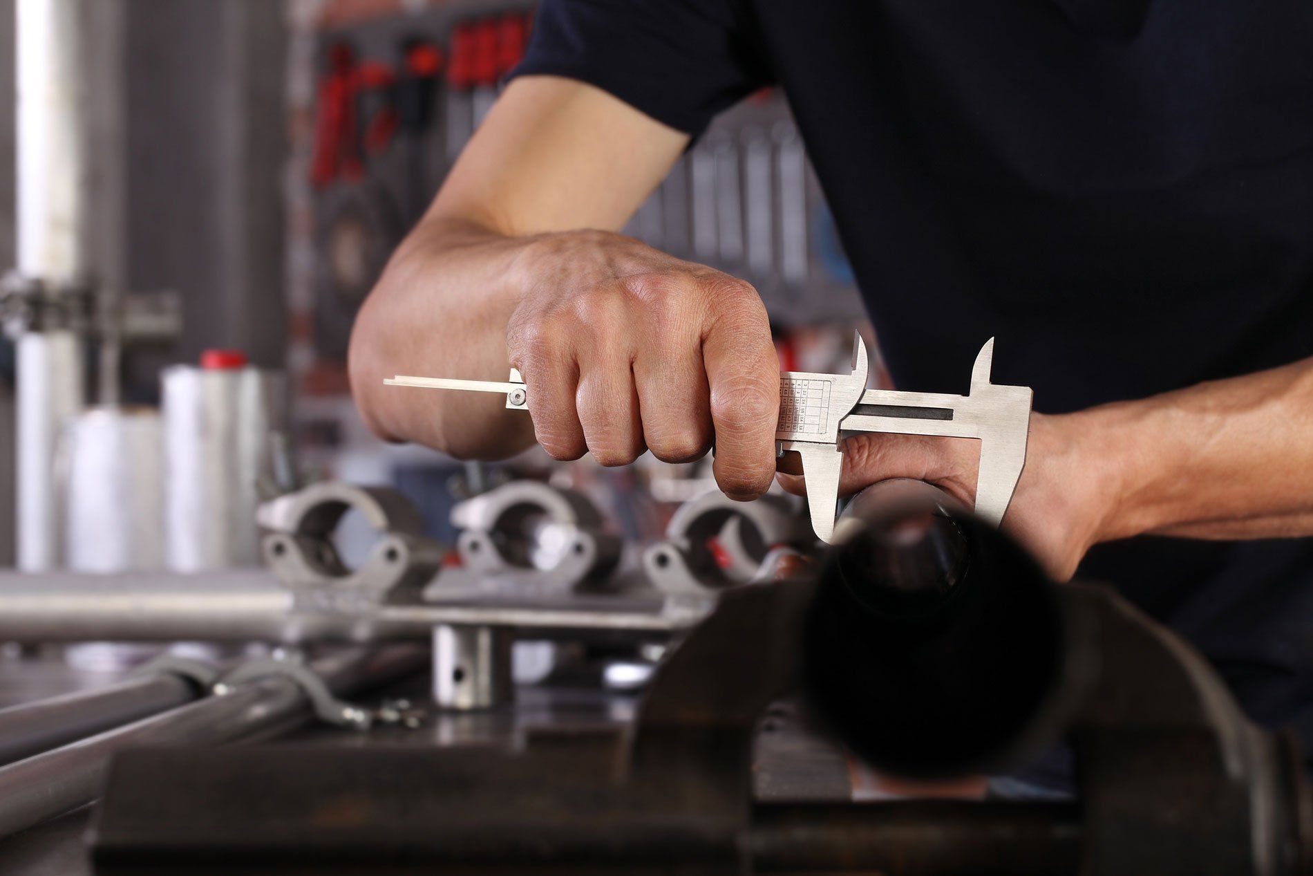 A worker at a machine shop using a tool