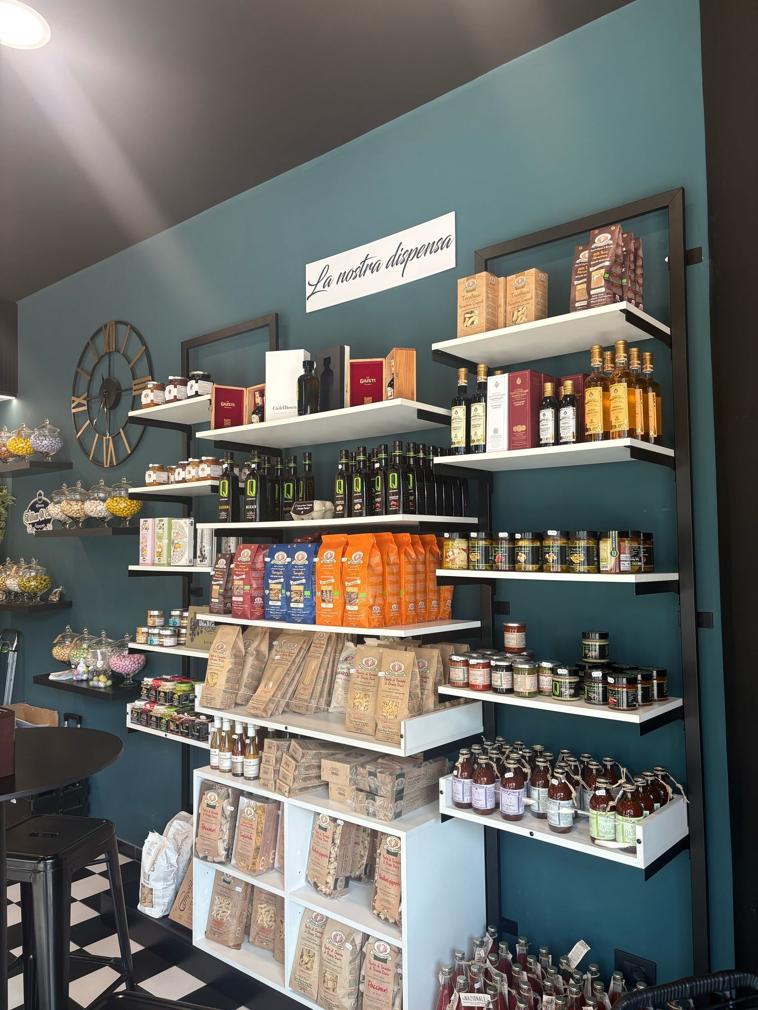 Shelves of packaged snacks and jars in a small teal shop interior