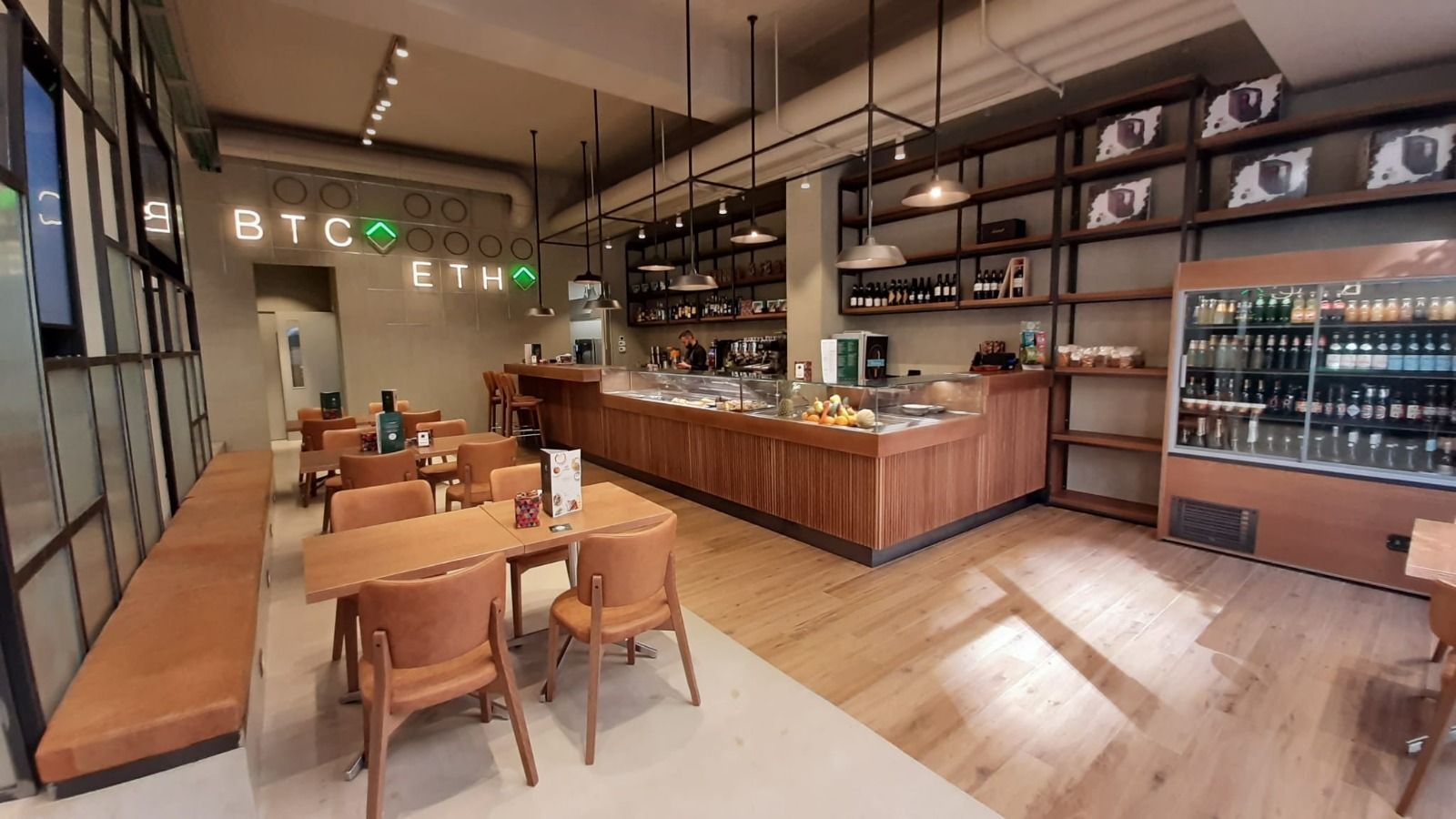 Brick-front deli counter with glass display cases in a casual restaurant interior
