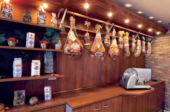 Wood-paneled coffee counter with hanging bags, shelves of products, and an espresso machine
