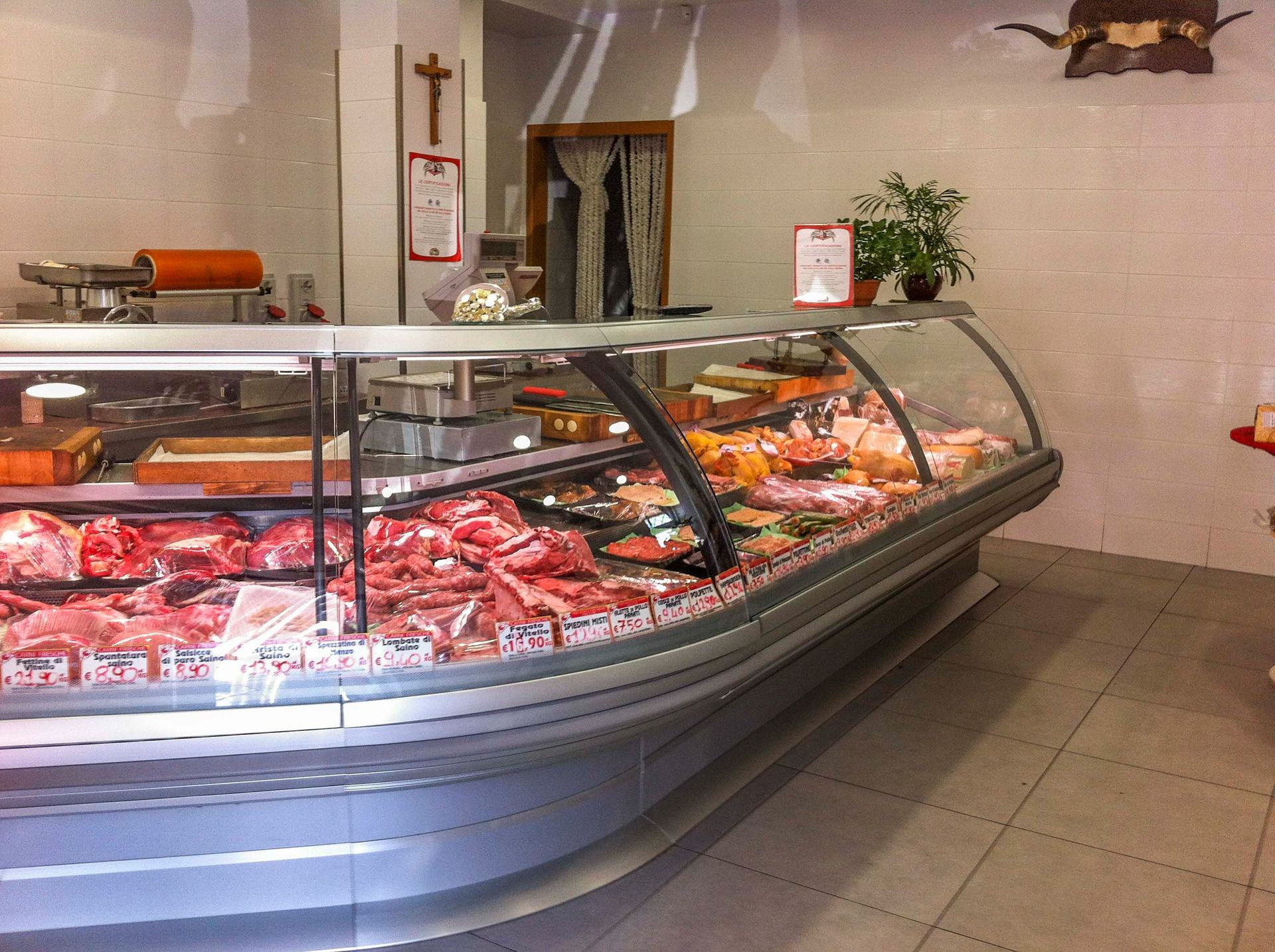 Butcher counter with assorted meats in a glass display case inside a shop