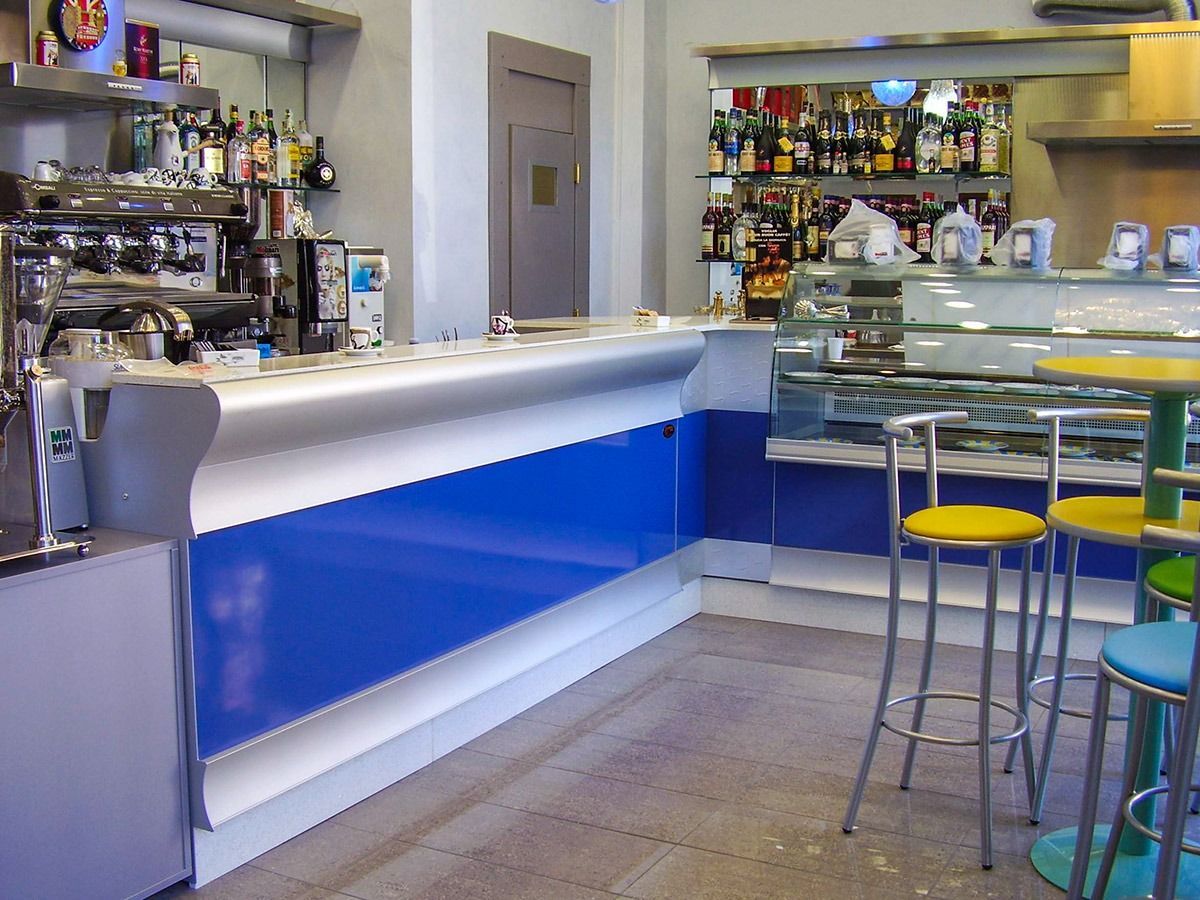 Modern café bar interior with blue-lit counter, stools, and display cases