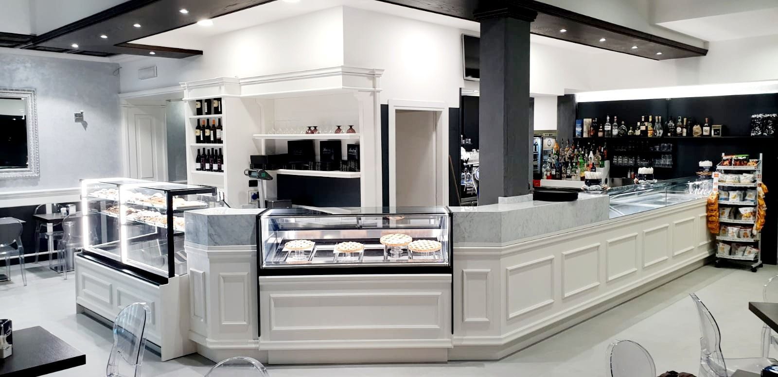 Modern white bakery counter with glass display cases in a bright retail store