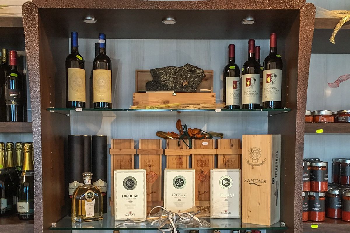 Wooden bar shelf with wine bottles, liquor bottles, wooden boxes, and a decorative centerpiece