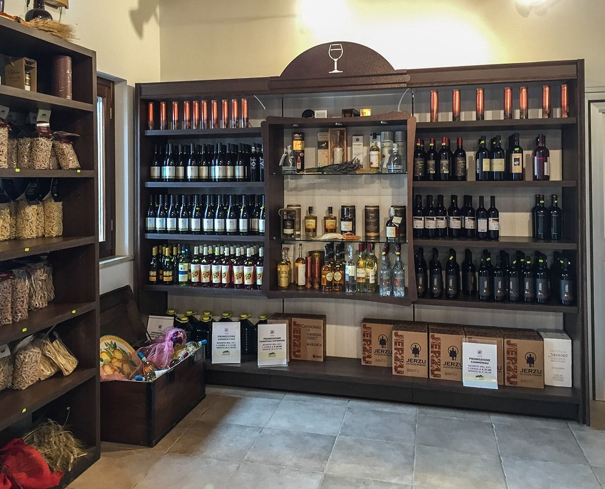 Liquor store display with shelves of wine, spirits, and gift boxes in a warmly lit interior