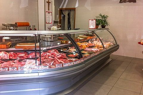 Butcher shop meat display case with assorted cuts of red meat and sausages