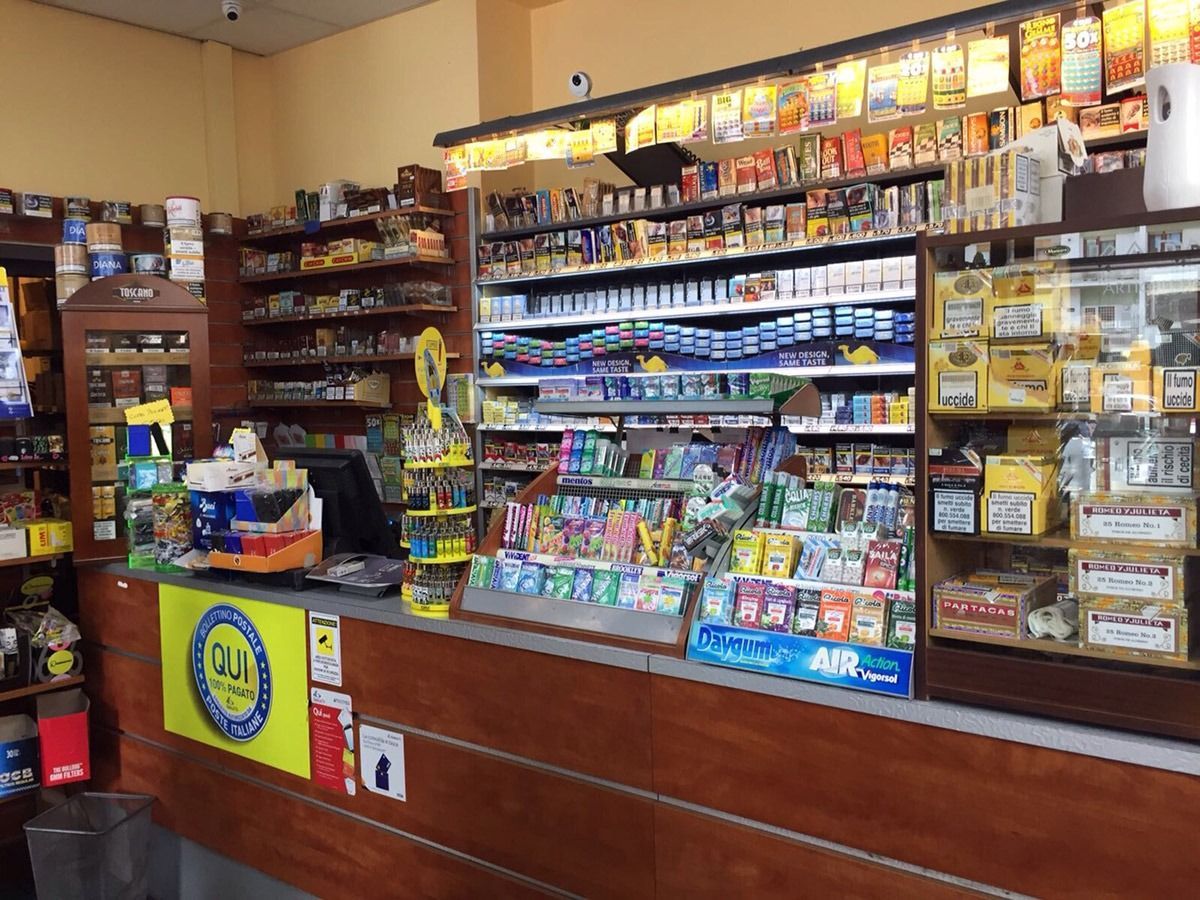 Convenience store counter with snacks, cigarettes, and tobacco products displayed behind the register.
