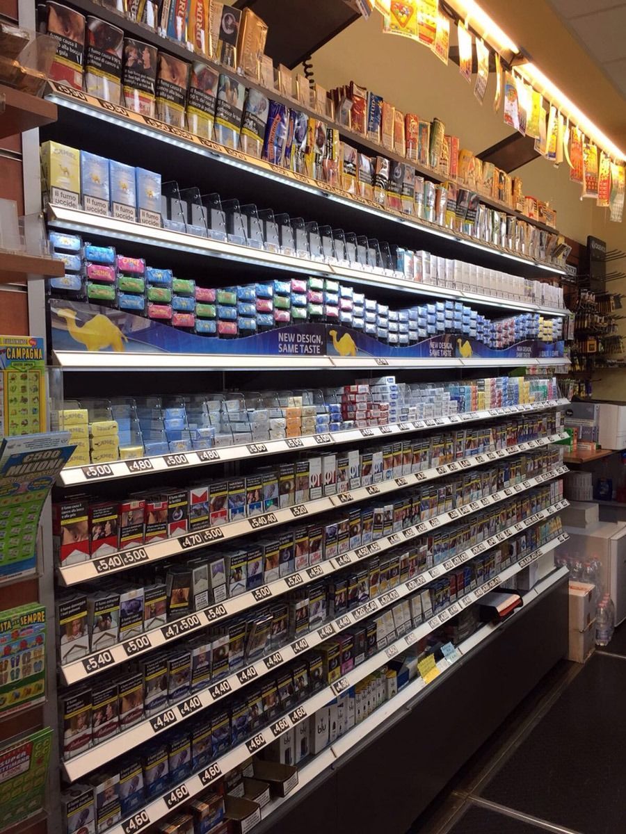 A store aisle lined with colorful rows of packaged snacks and small goods on shelves.