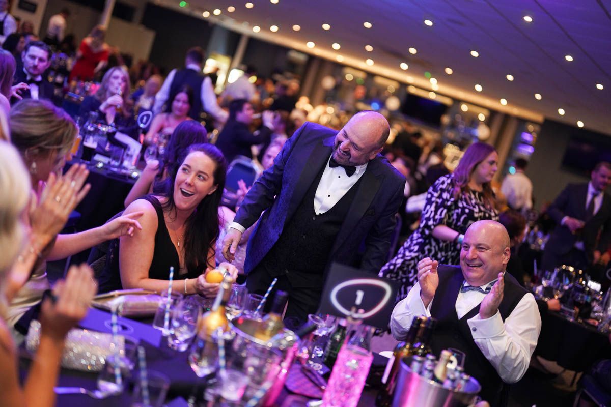 Magician Paul Roberts performs at an event in Cheshire, the faces of the audience all look thrilled and amazed.