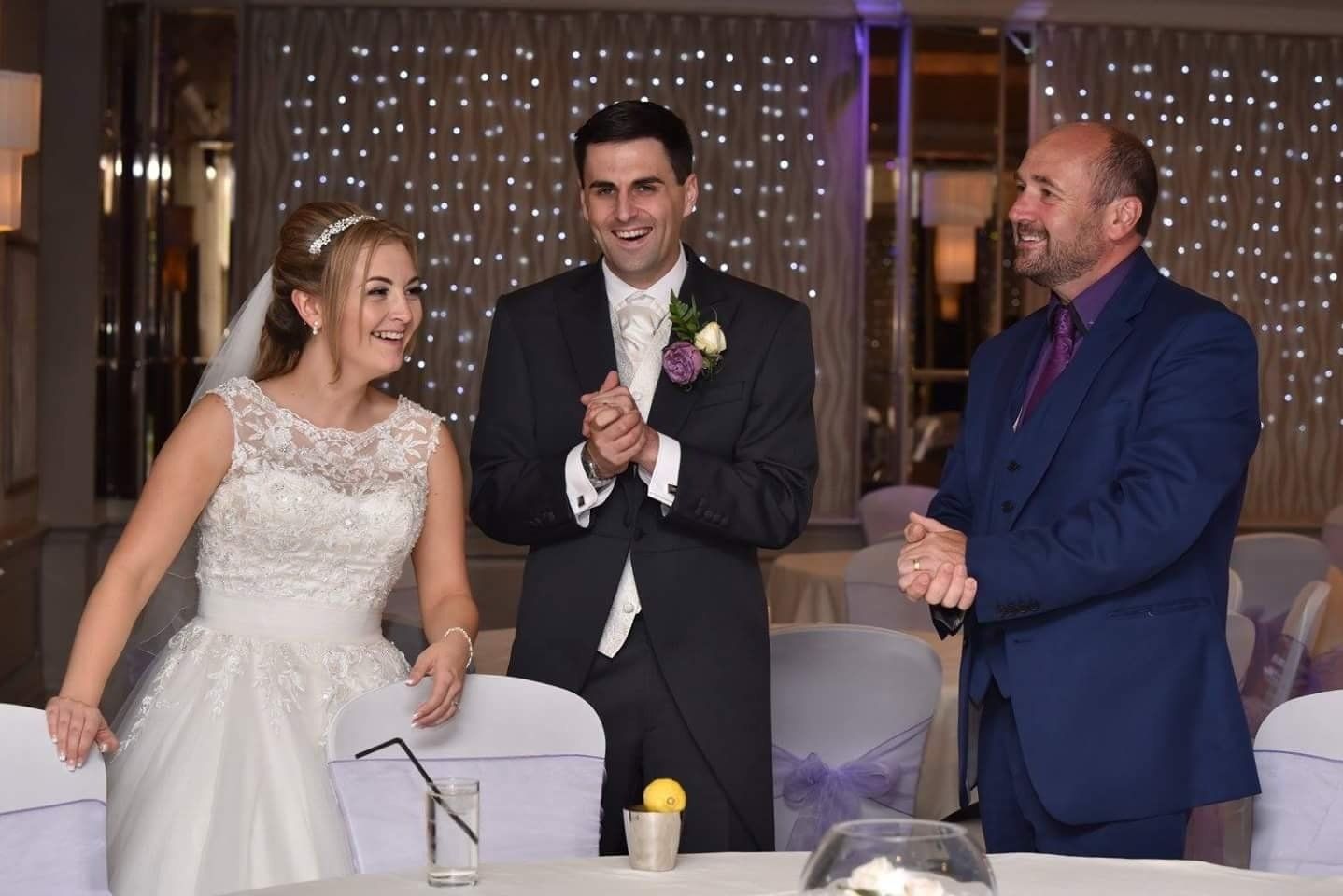 A bride and groom are standing next to each other at a wedding reception.
