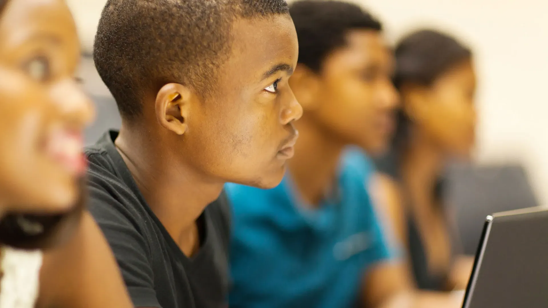Students attentively listening in a classroom.