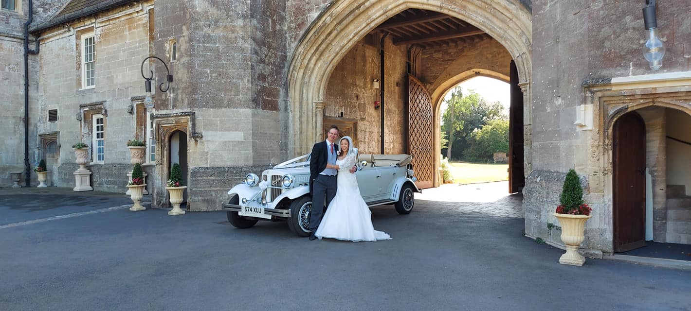 Spirit Wedding Cars | A bride and groom are posing for a picture in front of a castle.