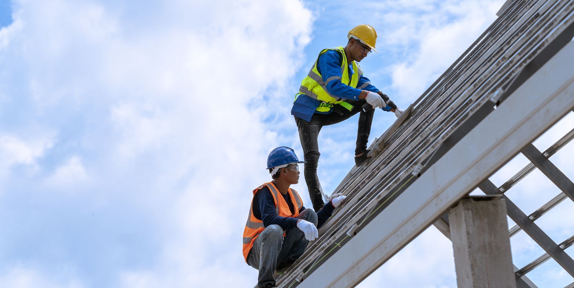 Construction worker installing new roof under construction residential building | Loveland CO 