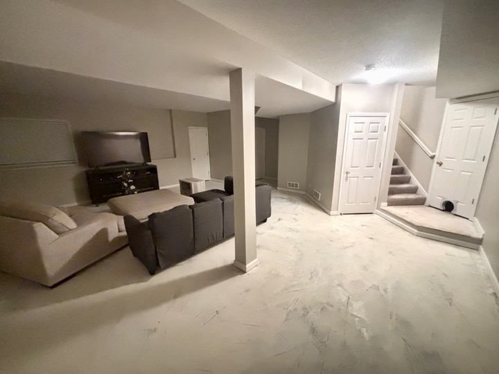 Painted basement walls and white trim with the concrete floor still exposed.