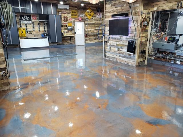 a garage with a shiny metallic floor and a flat screen tv .