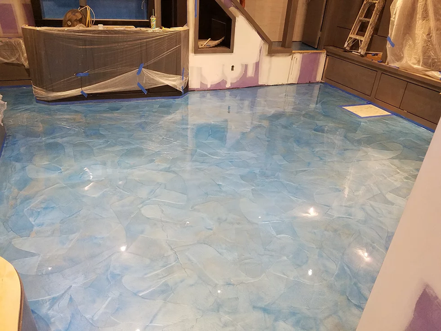 a blue marble floor in a room with a ladder in the background .