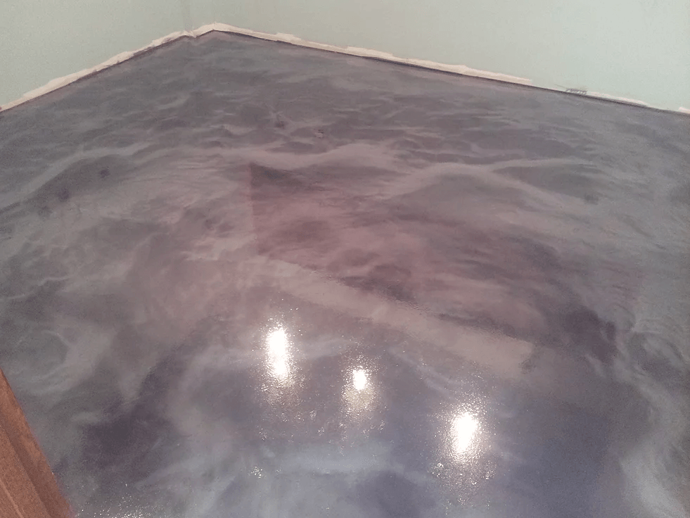 a shiny metallic floor in a room with lights on it .