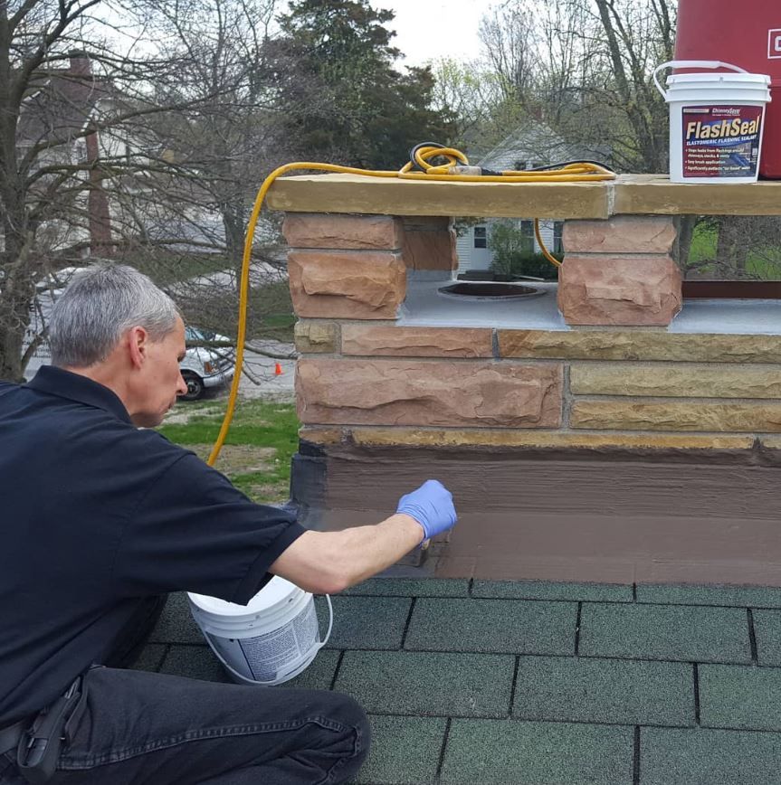 A man is working on a roof with a bucket that says flake on it